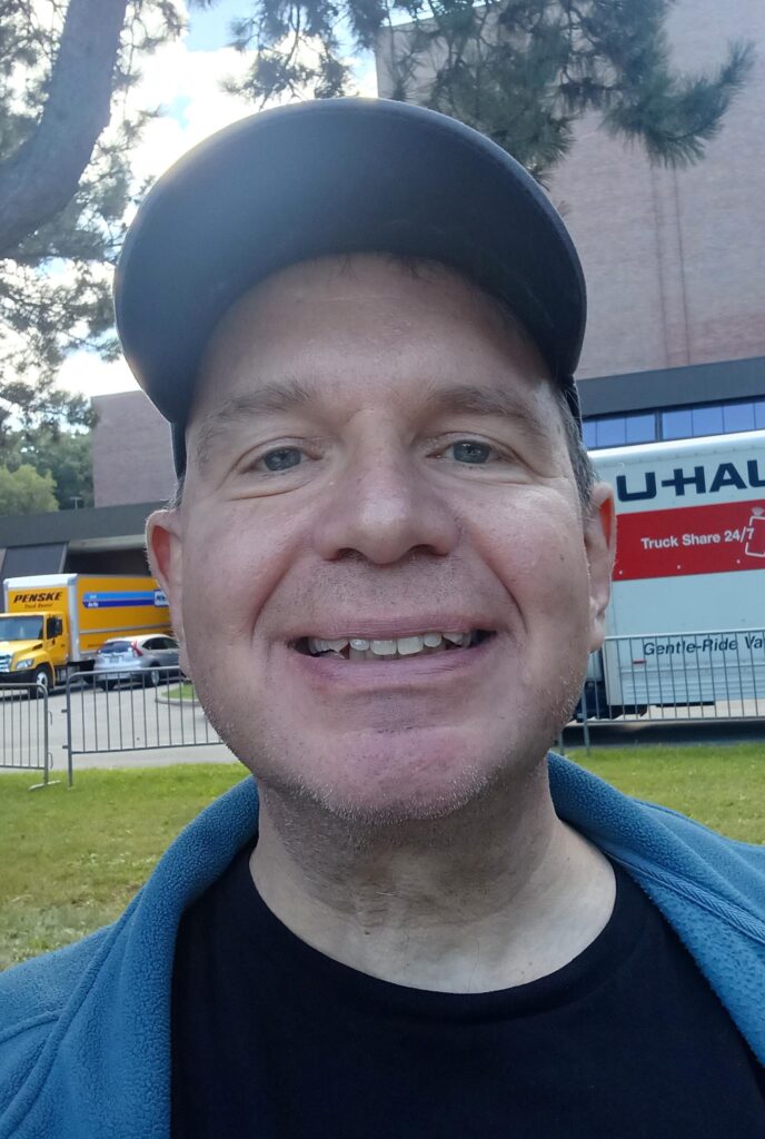 Author Jim Toner smiling outdoors at the Better Off Read Festival in Lewiston, New York.